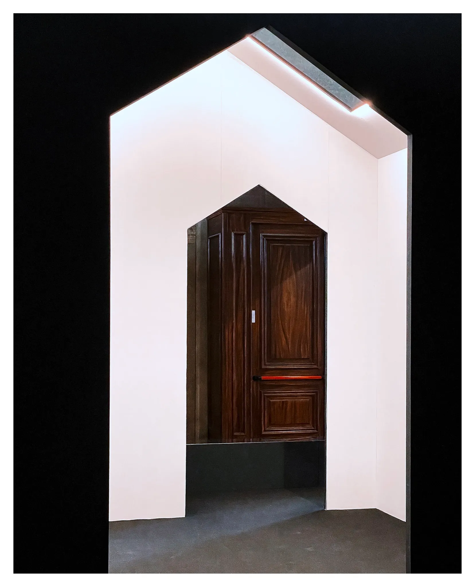 White portal in front of a wooden door – Mimmo Jodice. L'enigma della luce, Castello di Udine, 2025