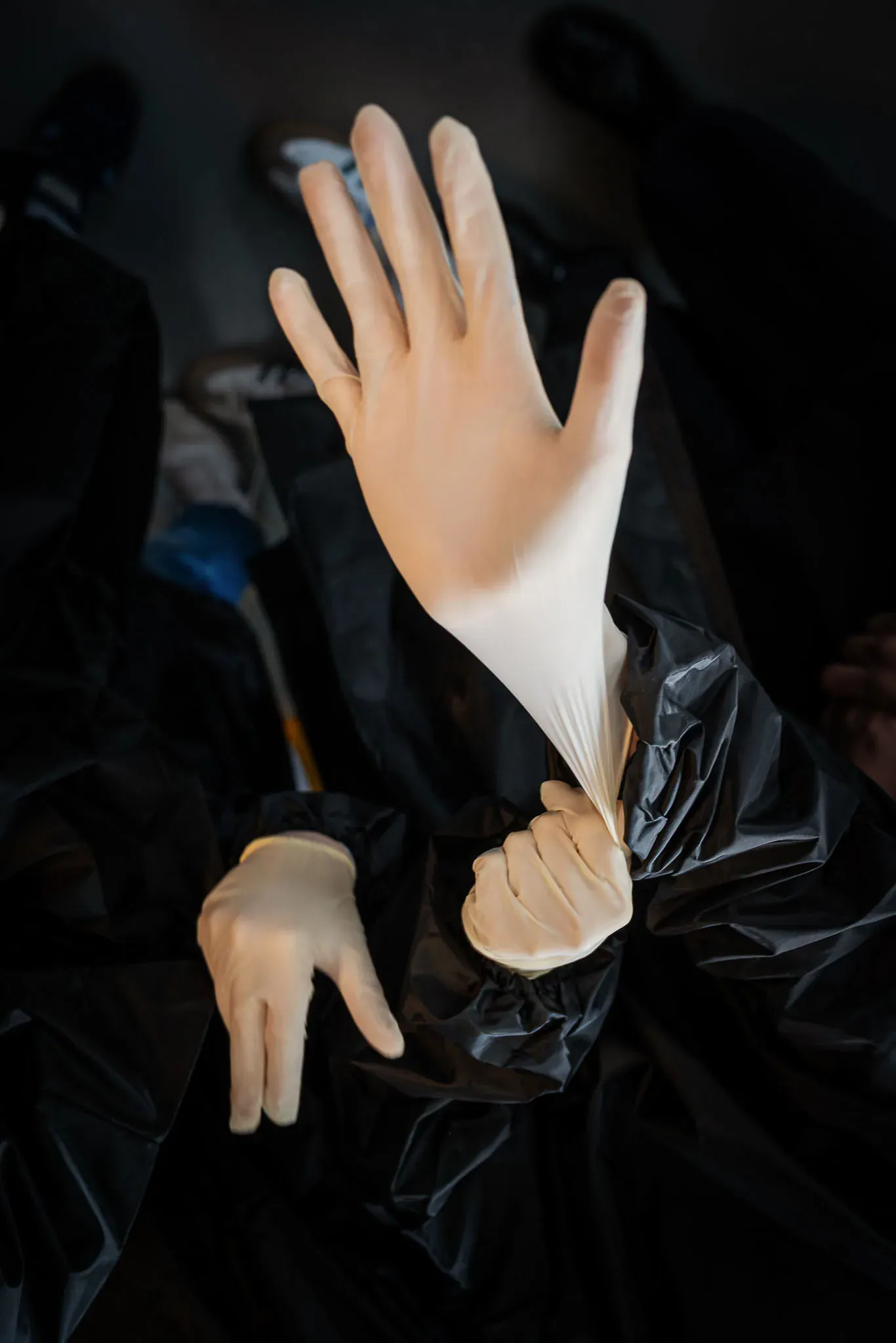 Weißer Handschuh als Objekt vor dunklem Grund.